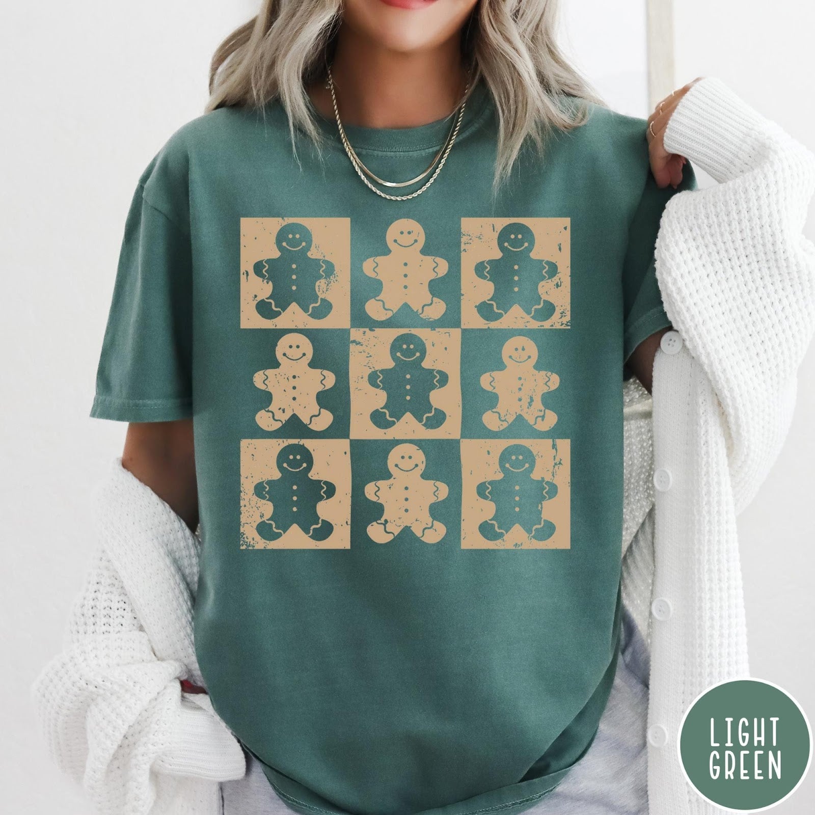 Comfort Colors tee in light green featuring grid style graphic with alternating tan and green gingerbread cookie patterns