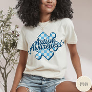 Comfort Colors tee in Ivory featuring casual style with a blue checkered puzzle piece Autism Awareness graphic