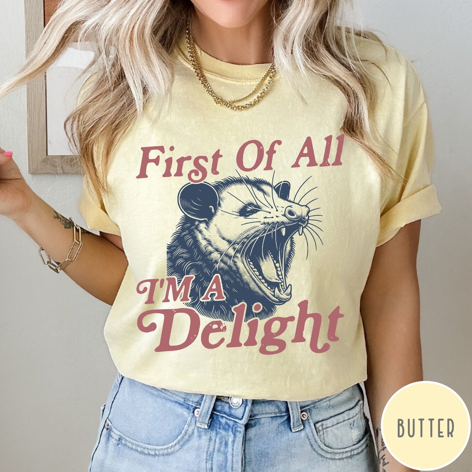 Comfort Colors tee in Butter featuring illustrative opossum graphic with text First Of All I'm A Delight