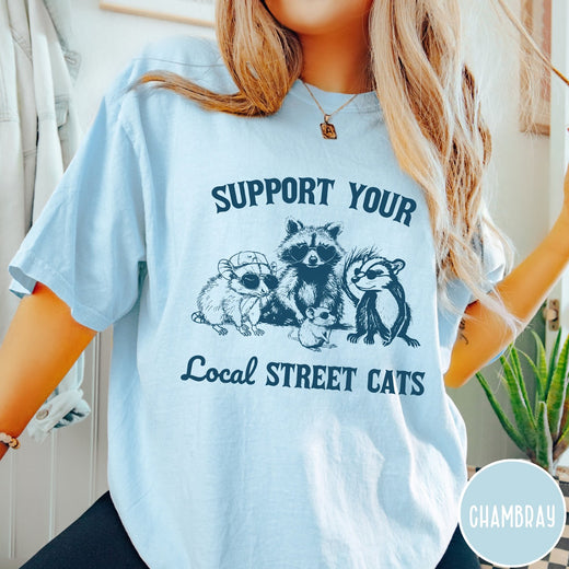 Comfort Colors tee in Chambray featuring illustration style graphic of a raccoon, opossum, and skunk wearing sunglasses