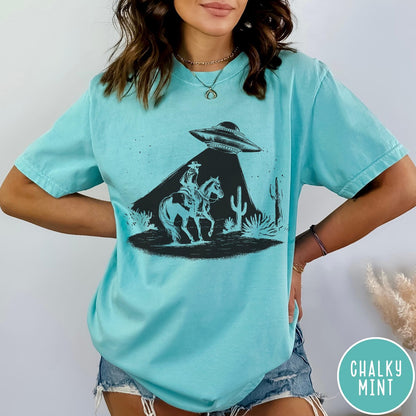 Comfort Colors tee in Chalky Mint featuring western graphic style cowboy on horseback being abducted by a UFO