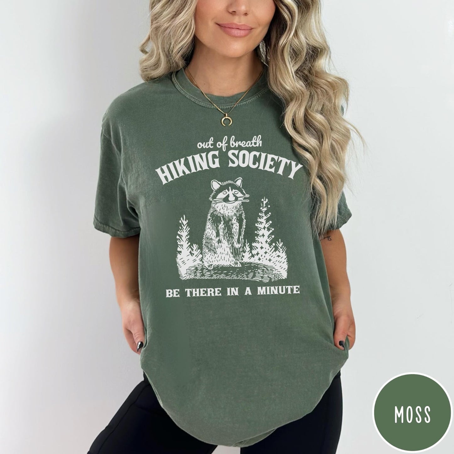 Comfort Colors tee in Moss featuring outdoor style graphic of a raccoon standing in the forest