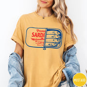 Comfort Colors tee in Mustard featuring vintage style sardine tin graphic with red text and blue fish