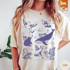 Comfort Colors tee in Ivory featuring vintage style graphic of various animals with butterfly wings and clouds