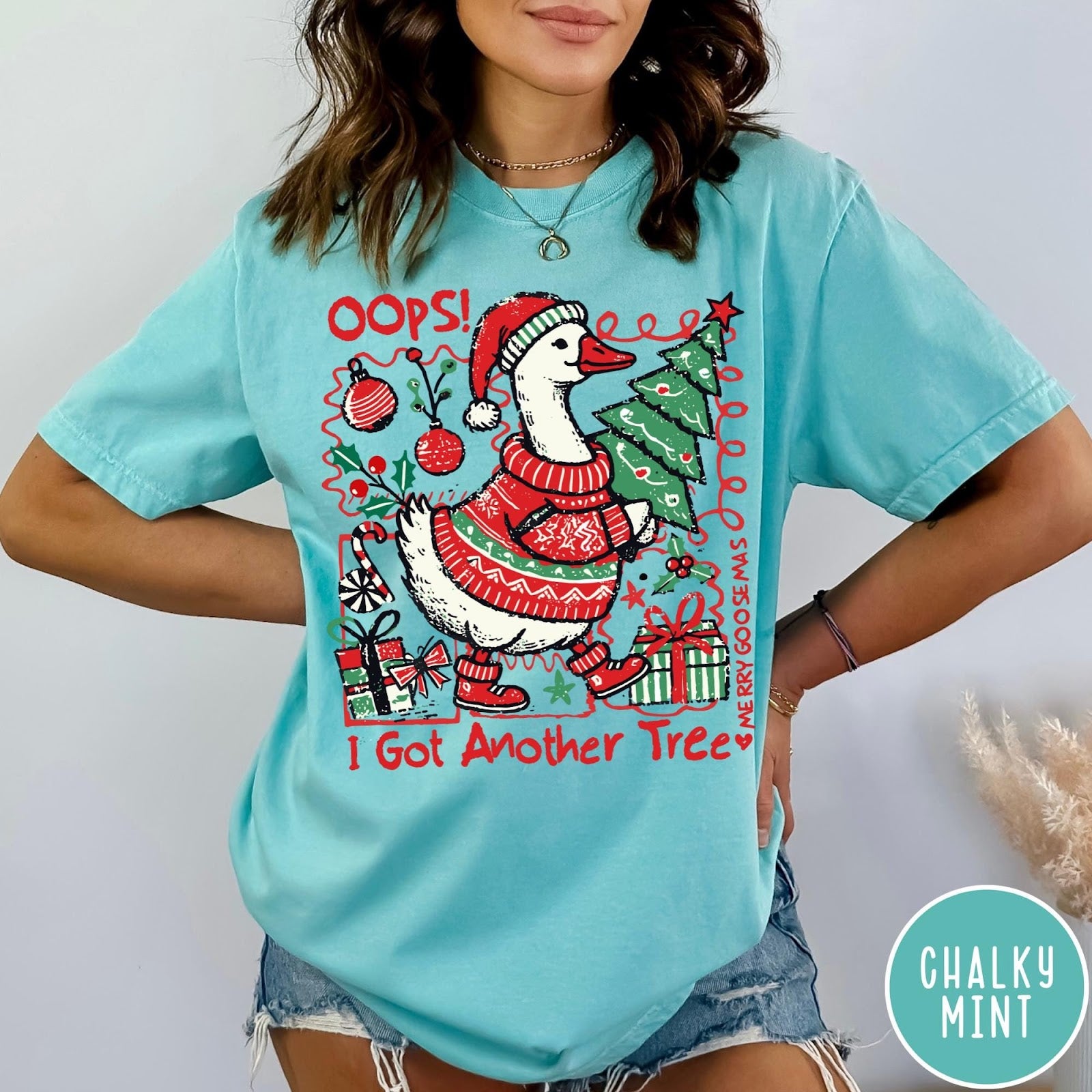 Comfort Colors tee in Chalky Mint featuring festive graphic design of a goose wearing a sweater and hat