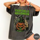Comfort Colors tee in Pepper featuring Halloween graphic with a witch, skeleton, ghost, and a dripping pumpkin.