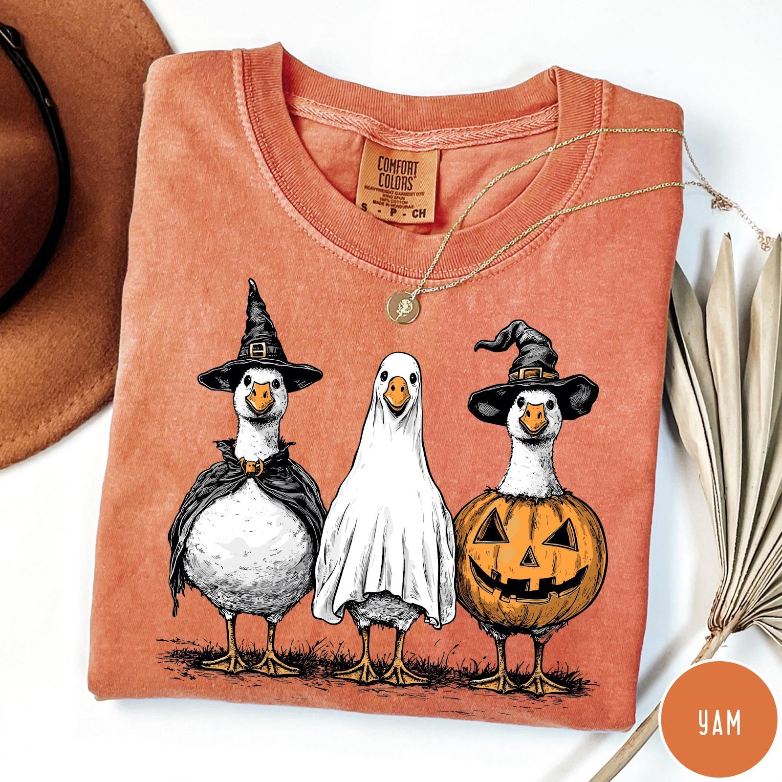 Comfort Colors tee in Yam featuring Halloween graphic with three geese dressed as a witch, ghost, and pumpkin
