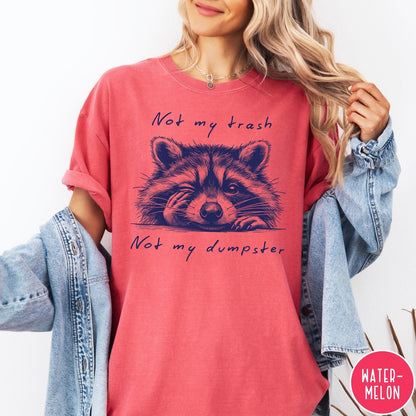 Comfort Colors tee in Watermelon featuring graphic illustration of a winking raccoon with text Not My Trash