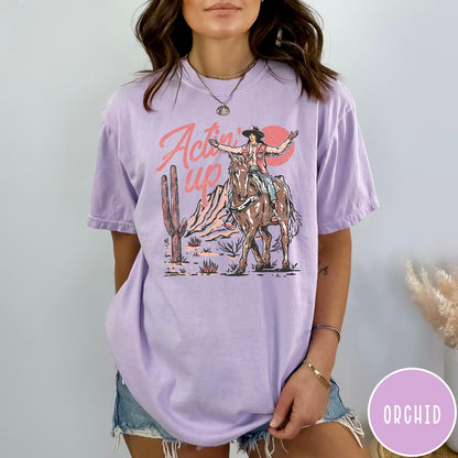 Comfort Colors tee in Orchid featuring western style graphic of a cowgirl riding a horse in the desert