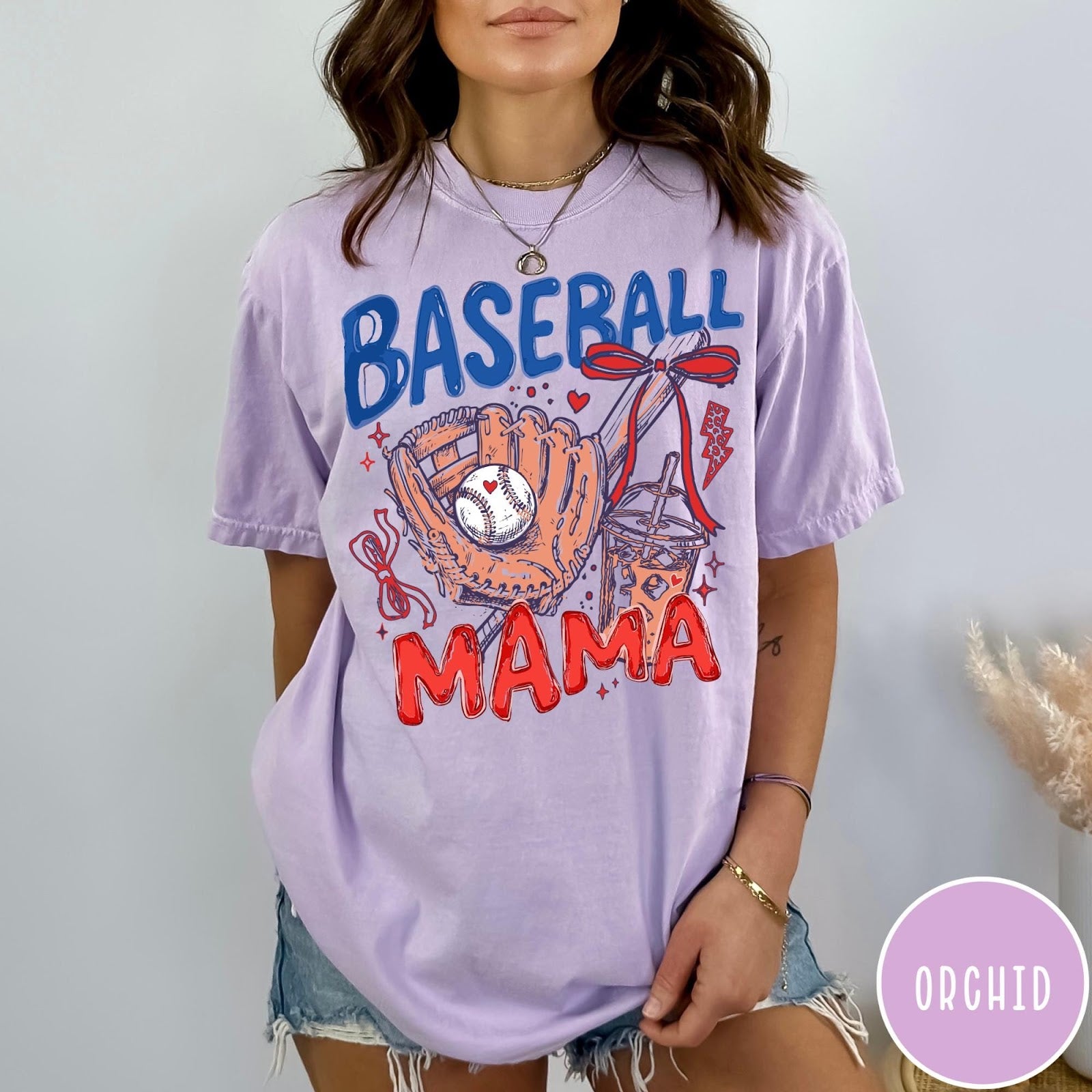 Comfort Colors tee in Orchid featuring baseball design with glove, ball, iced coffee, and red bow graphic