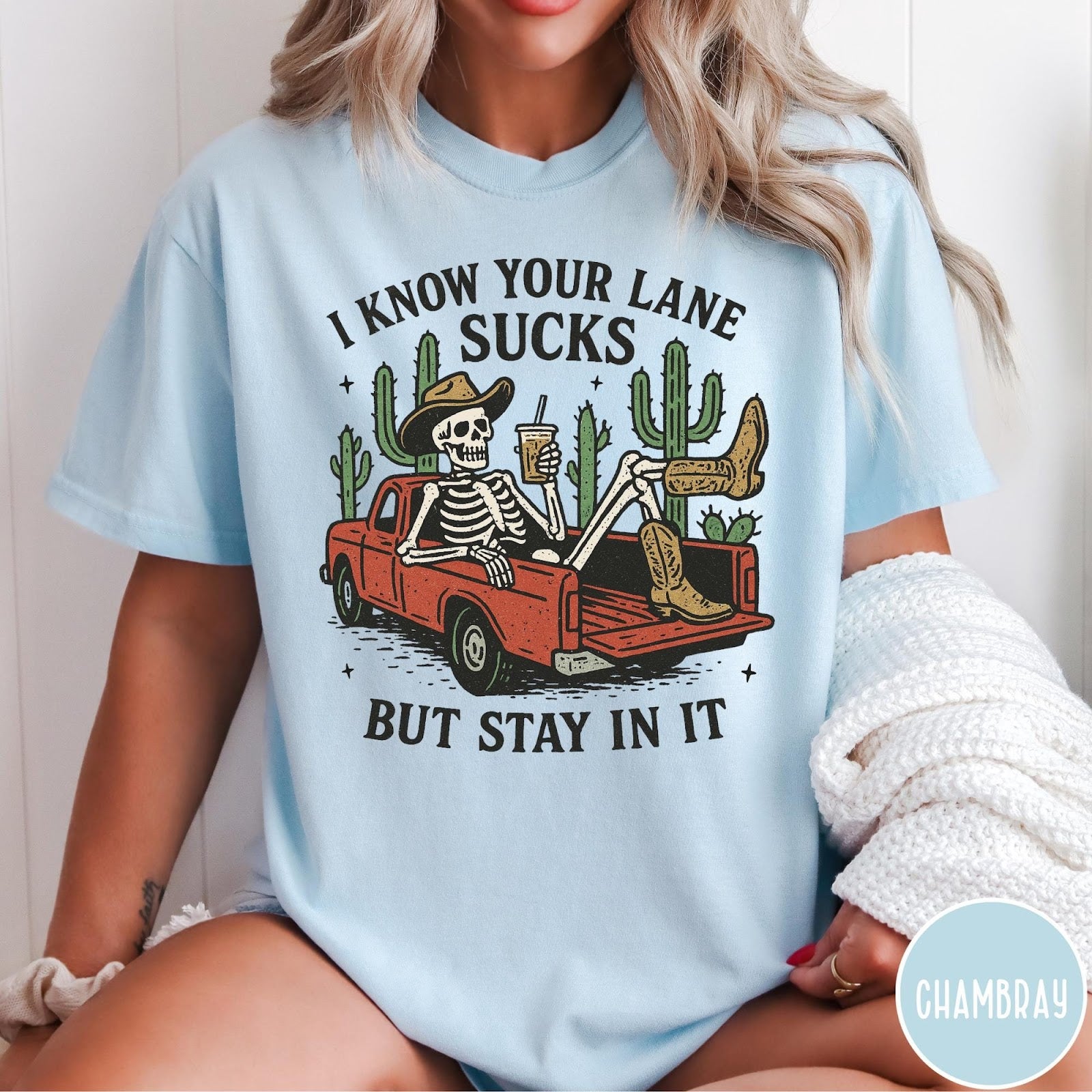 Comfort Colors tee in Chambray featuring western skeleton graphic with cowboy hat and boots in pickup truck