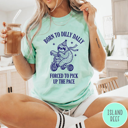 Comfort Colors tee in Island Reef featuring cute sloth on a tricycle graphic with Born to Dilly Dally text