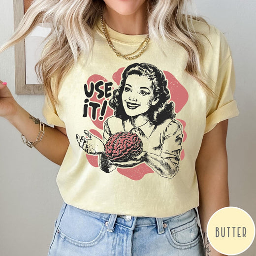 Comfort Colors tee in Butter featuring retro style graphic of a woman holding a human brain