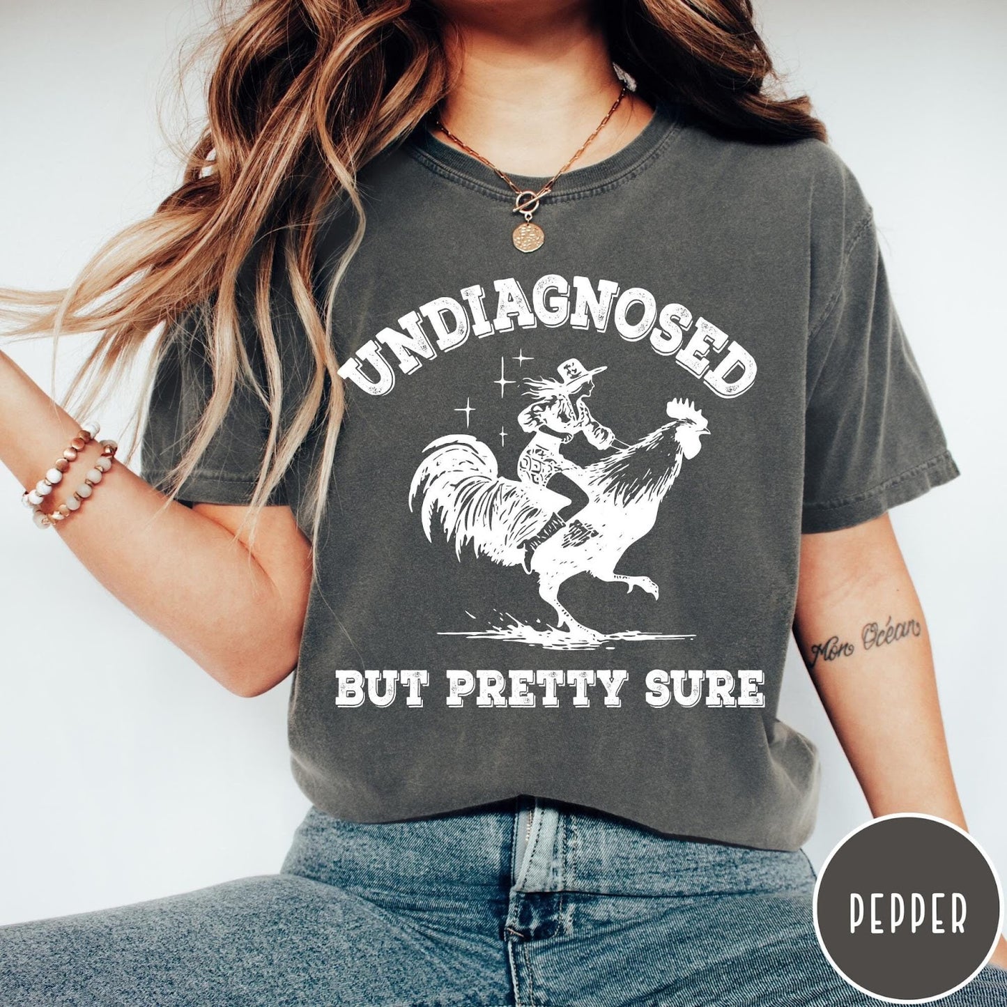 Comfort Colors tee in Pepper featuring western style graphic of a cowgirl riding a large rooster