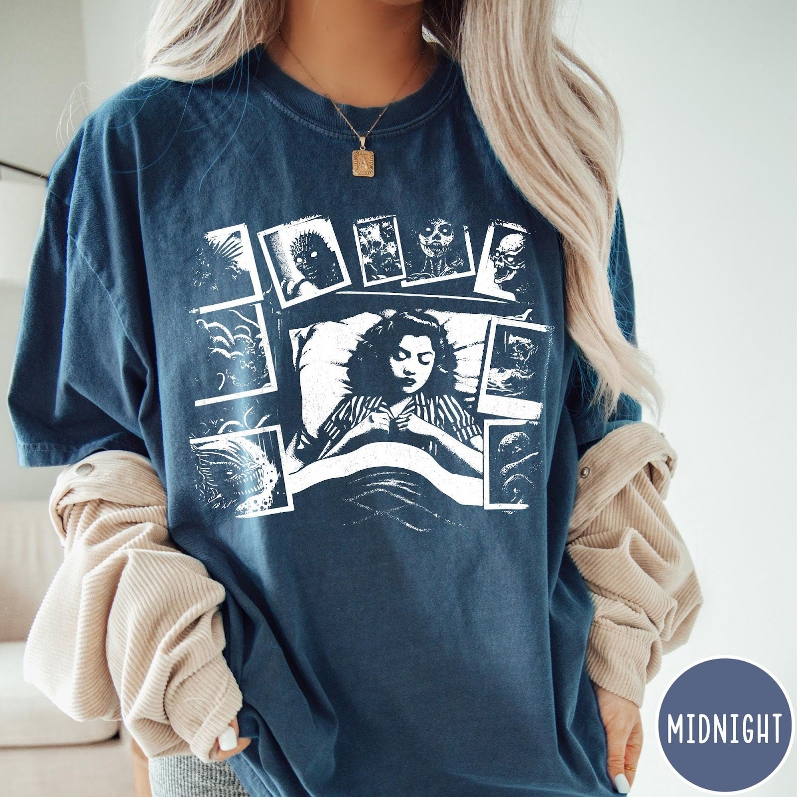 Comfort Colors tee in Midnight featuring graphic style illustration of a woman sleeping surrounded by horror polaroids