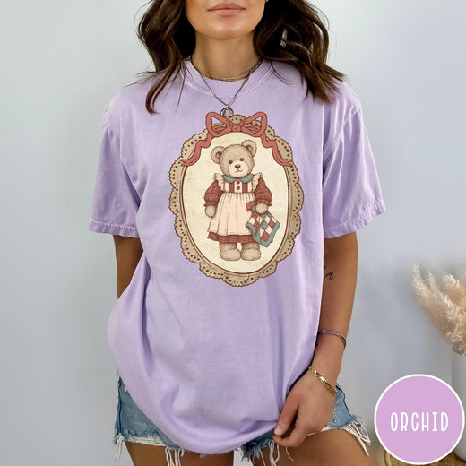 Comfort Colors tee in Orchid featuring vintage style teddy bear graphic inside a decorative lace oval frame