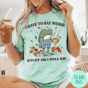 Comfort Colors tee in Island Reef featuring illustrative frog graphic with coffee cup and various forest mushrooms