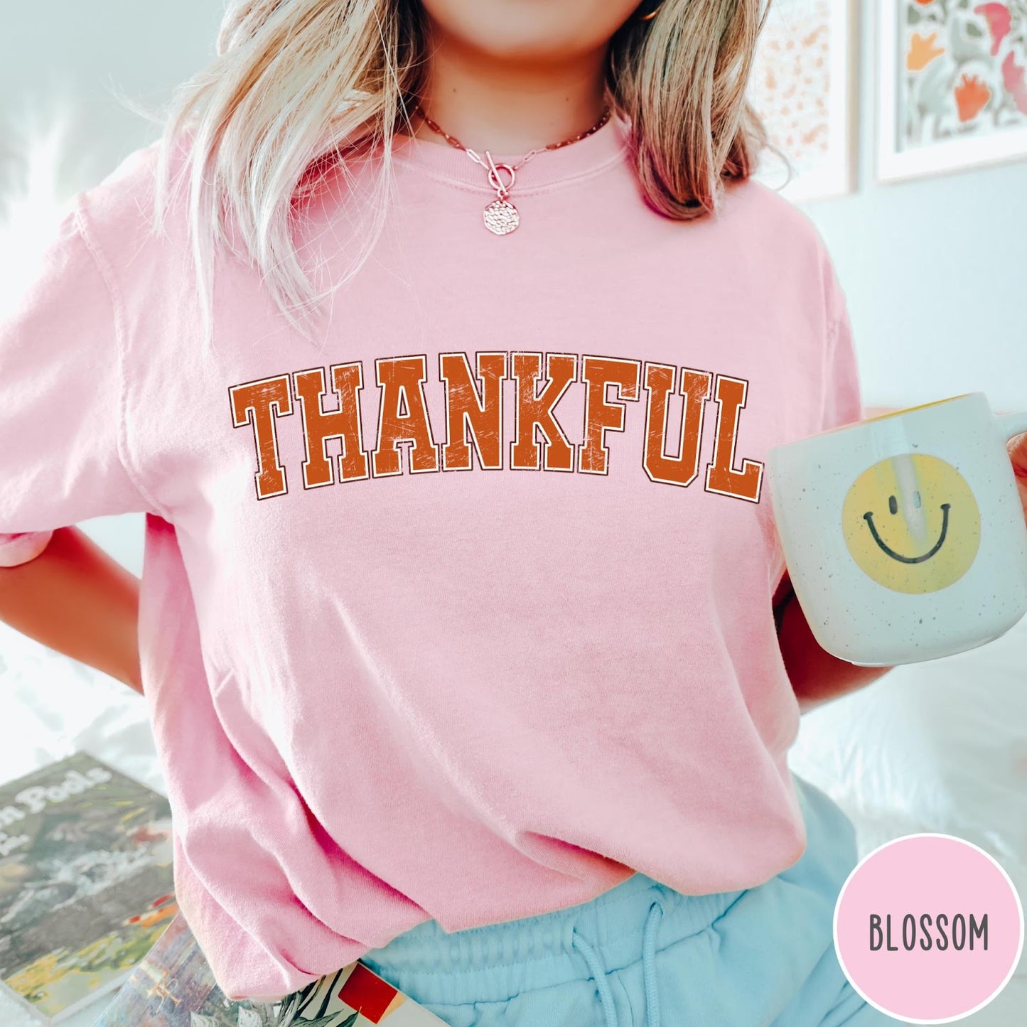 Comfort Colors tee in Blossom featuring typography graphic with the word Thankful in an arched varsity style