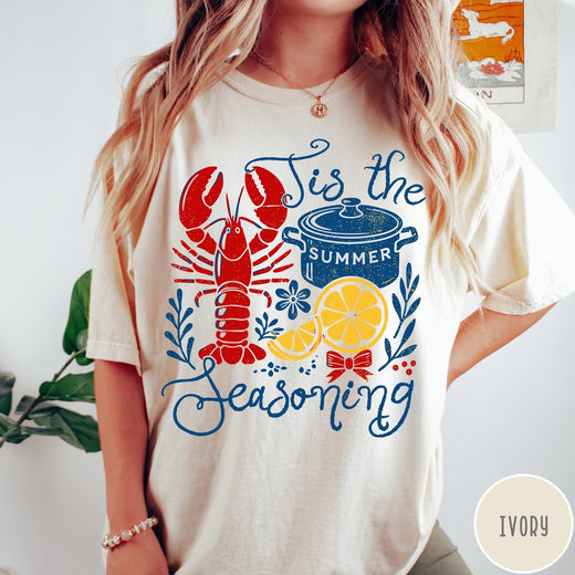Comfort Colors tee in Ivory featuring lobster boil graphic with a lobster, cooking pot, and lemon slices.
