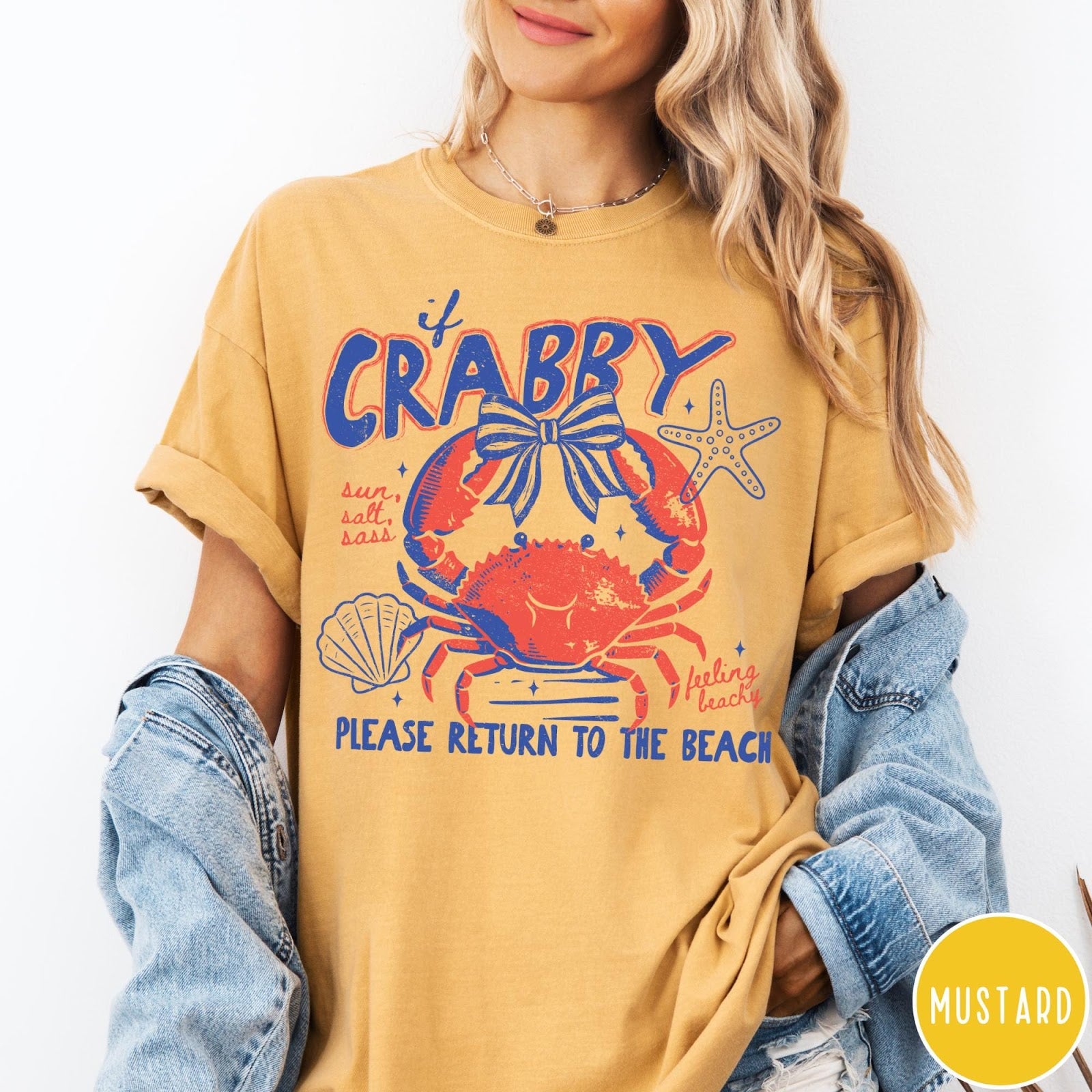 Comfort Colors tee in Mustard featuring beachy crab graphic with bow, starfish, seashell, and coastal text