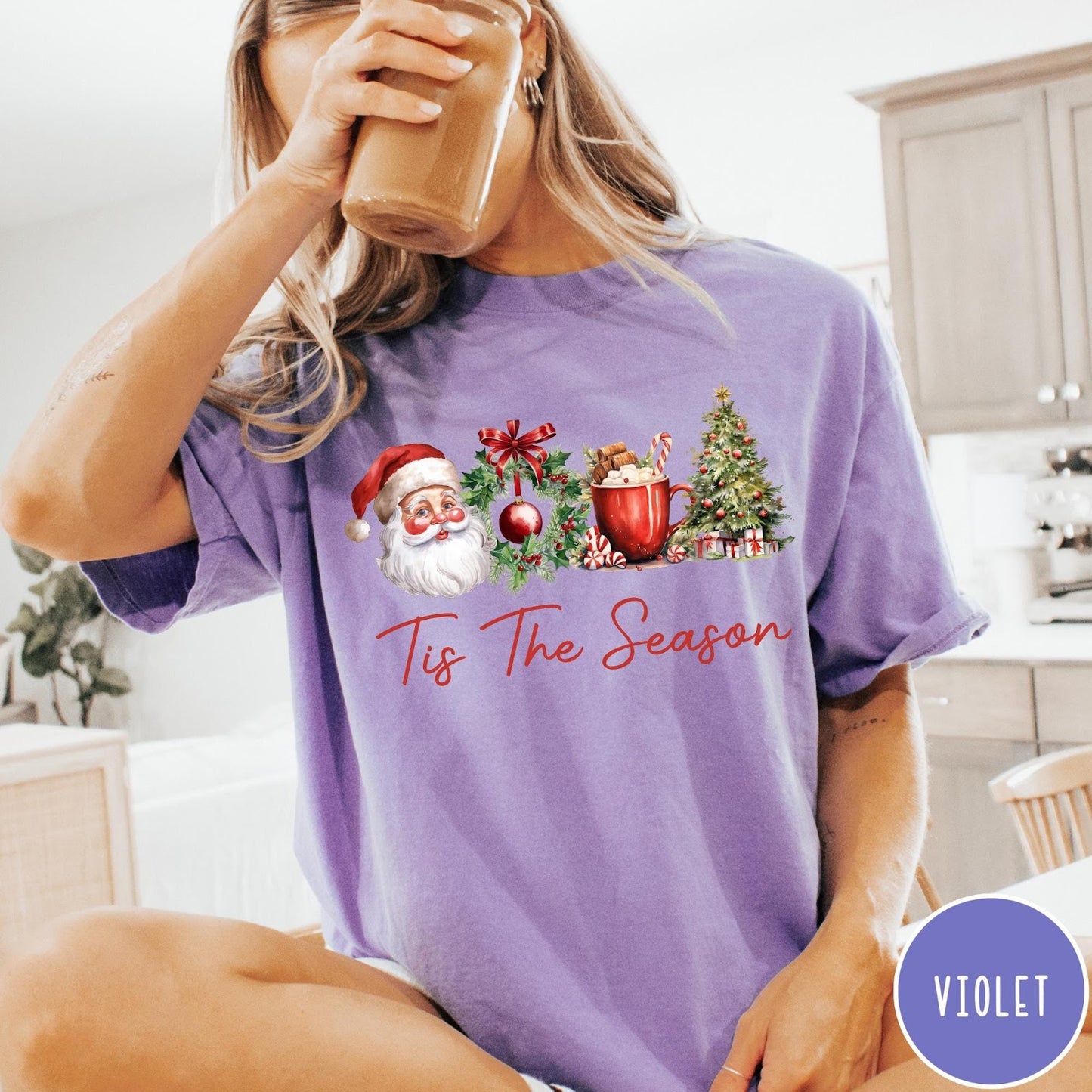 Comfort Colors tee in Violet featuring holiday design with Santa, wreath, hot cocoa, and Christmas tree graphic