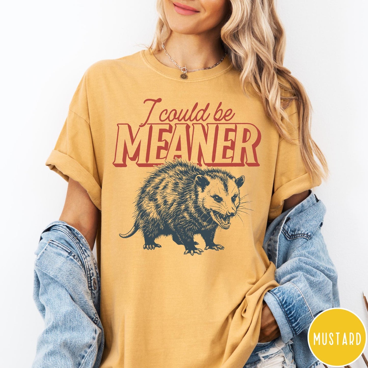 Comfort Colors tee in Mustard featuring a graphic design of a hissing opossum with text I could be meaner