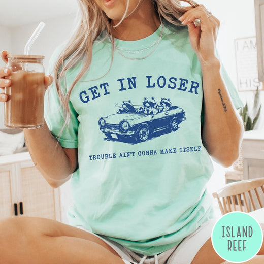 Comfort Colors tee in Island Reef featuring vintage style graphic of three raccoons driving a convertible car