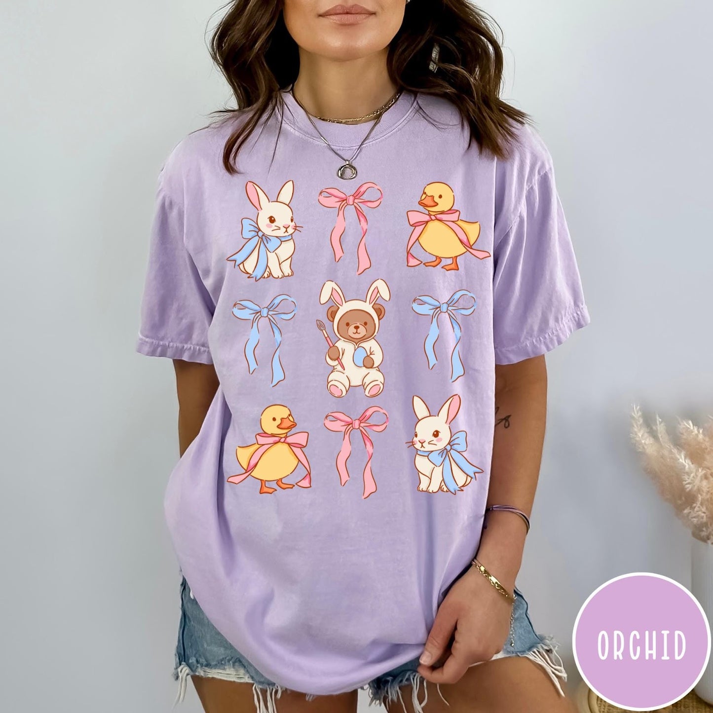 Comfort Colors tee in Orchid featuring vintage style graphic with Easter bunnies, ducks, and pink blue bows