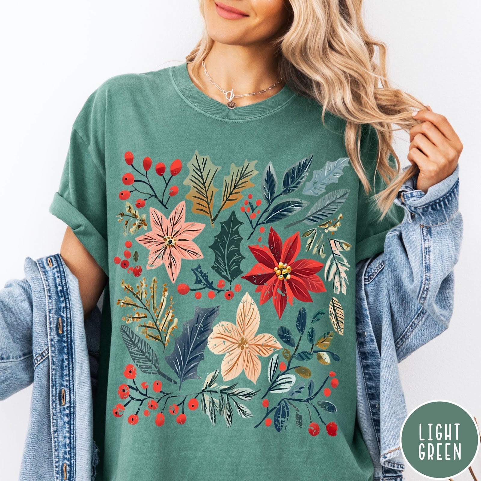 Comfort Colors tee in Light Green featuring winter florals graphic with poinsettias, holly leaves, and red berries.