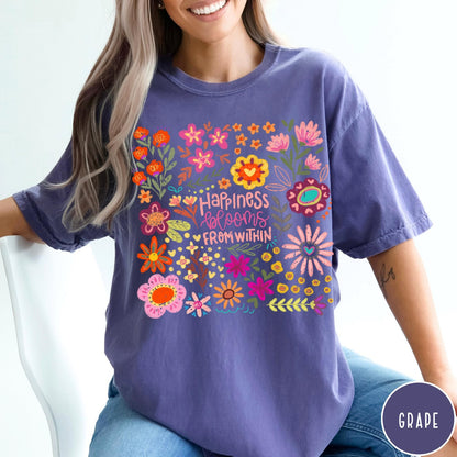 Comfort Colors tee in Grape featuring floral wildflowers design with Happiness Blooms Within text graphic description