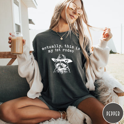 Comfort Colors tee in Pepper featuring western style graphic of a raccoon wearing a cowboy hat