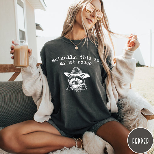 Comfort Colors tee in Pepper featuring western style graphic of a raccoon wearing a cowboy hat