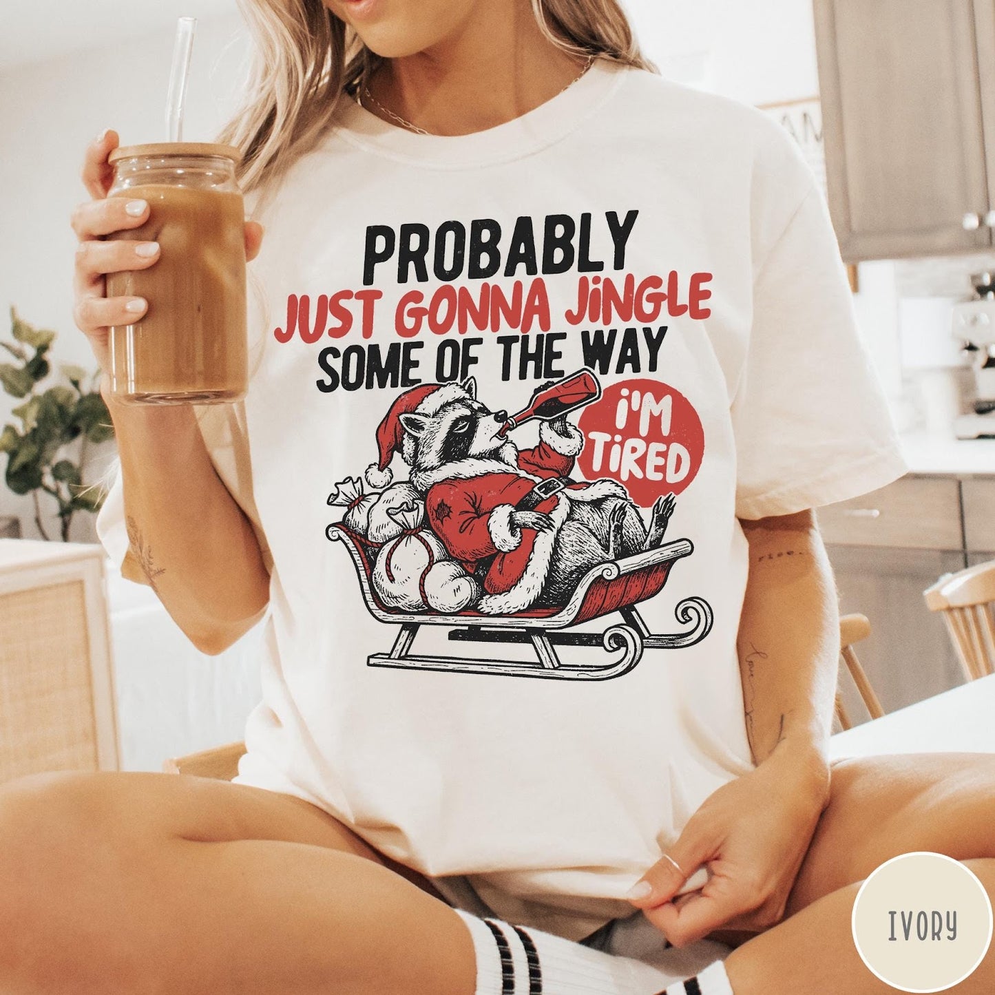 Comfort Colors tee in Ivory featuring festive raccoon graphic in a sleigh with holiday text design