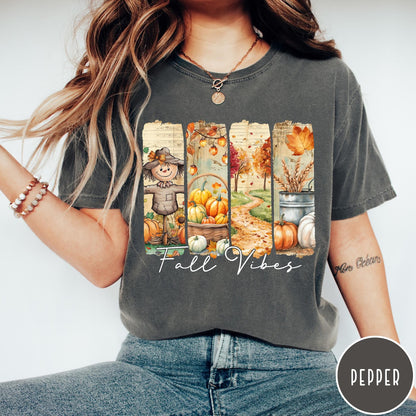 Comfort Colors tee in Pepper featuring autumn harvest graphic with a scarecrow, pumpkins, and fall foliage scenes