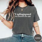 Comfort Colors tee in Pepper featuring mental health humor text that reads Undiagnosed but somethin aint right
