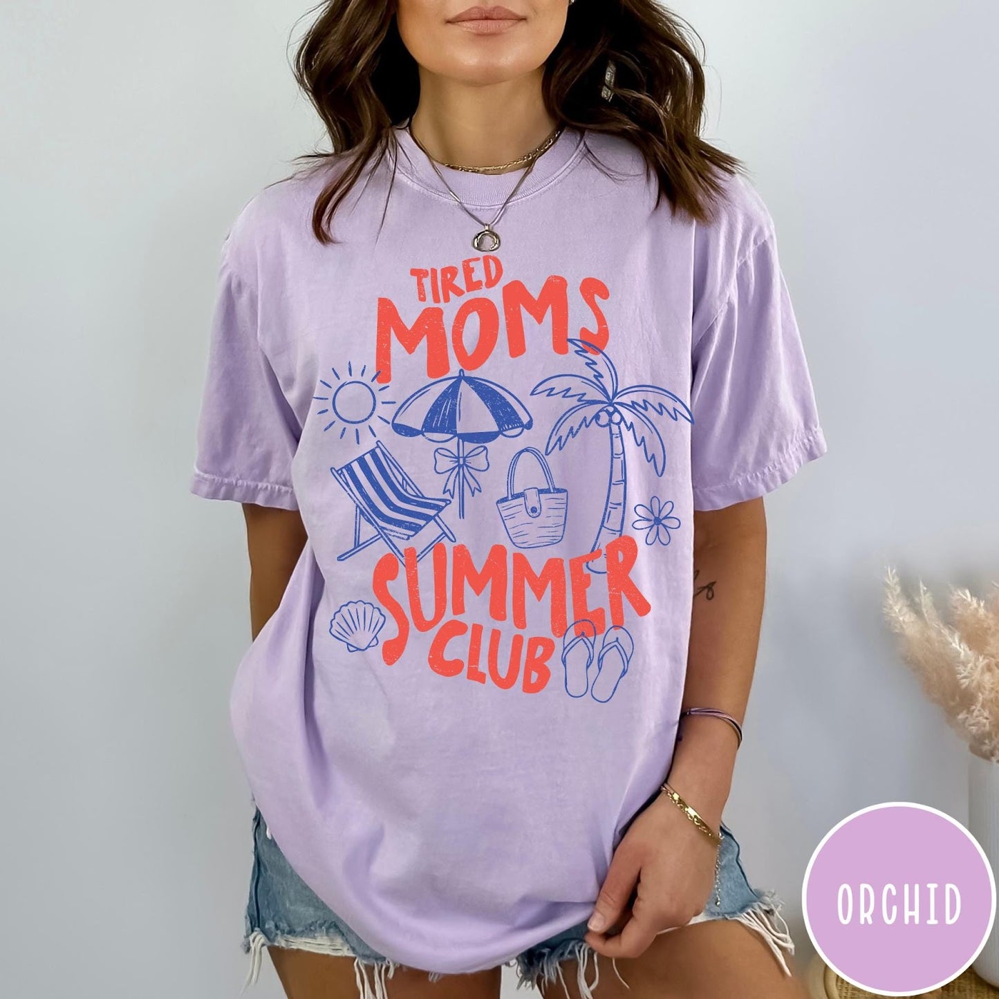 Comfort Colors tee in Orchid featuring beach vacation style graphic with sun, umbrella, palm tree, and bag