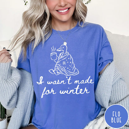 Comfort Colors tee in Flo Blue featuring line art graphic of a duck wrapped in a blanket drinking coffee