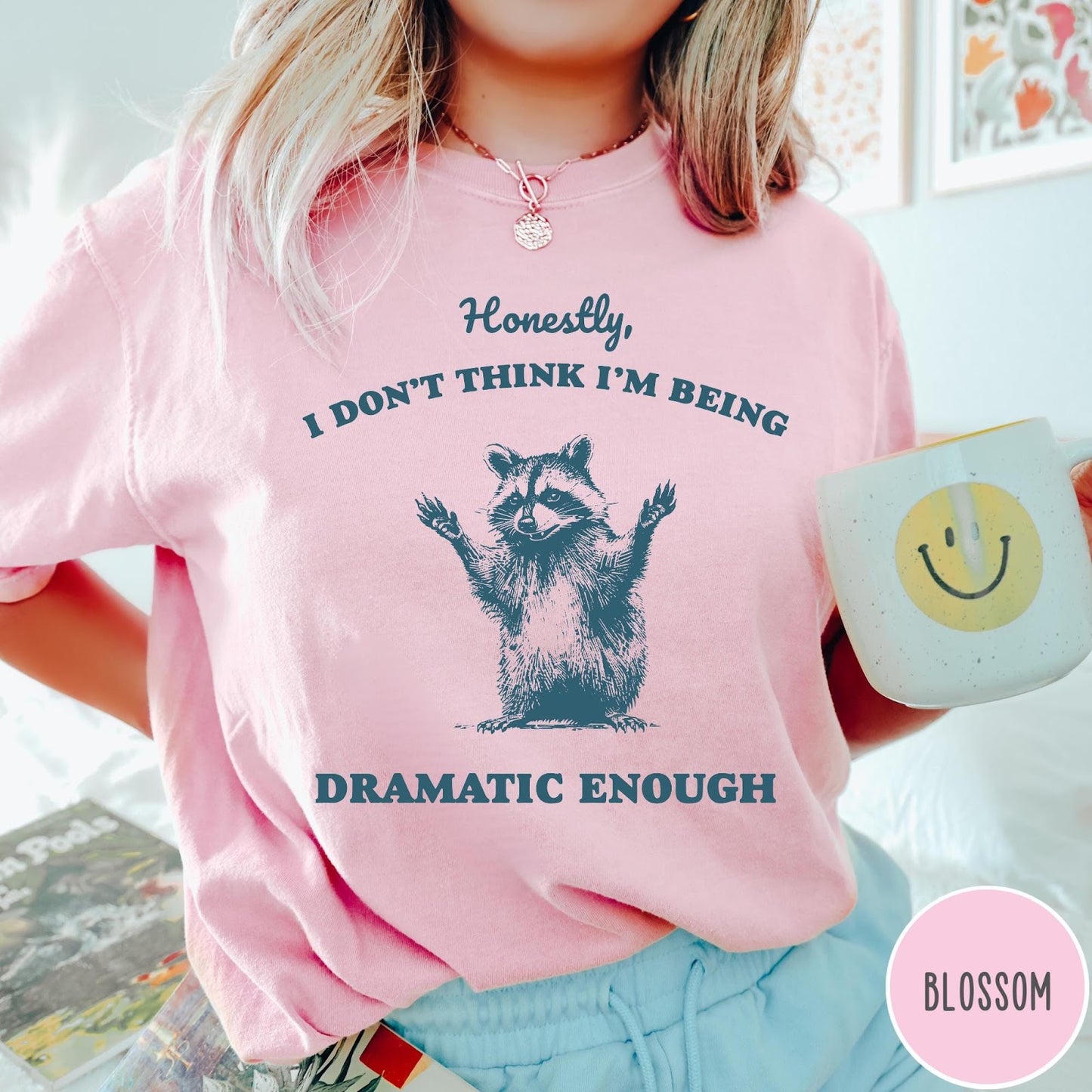 Comfort Colors tee in Blossom featuring vintage style graphic of a raccoon with arms raised and text