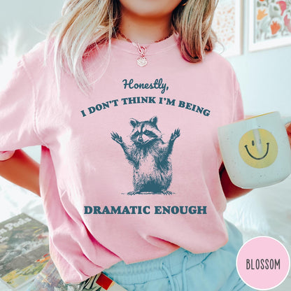 Comfort Colors tee in Blossom featuring vintage style graphic of a raccoon with arms raised and text