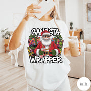 Comfort Colors tee in White featuring cartoon style Santa Claus wearing sunglasses and gold chain holding wrapping paper