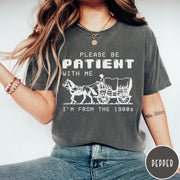 Comfort Colors tee in Pepper featuring pixel art style graphic of a horse drawn covered wagon