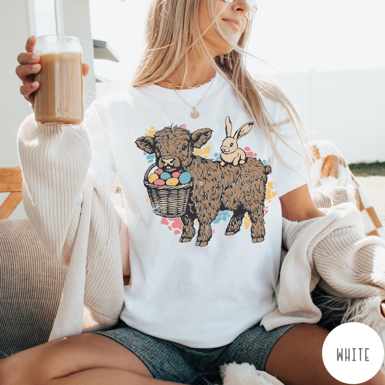 Comfort Colors tee in White featuring graphic style Highland cow and bunny with an Easter egg basket
