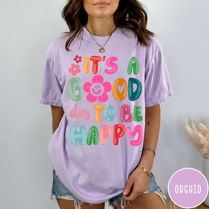 Comfort Colors tee in Orchid featuring typography and floral elements with a smiley face graphic design