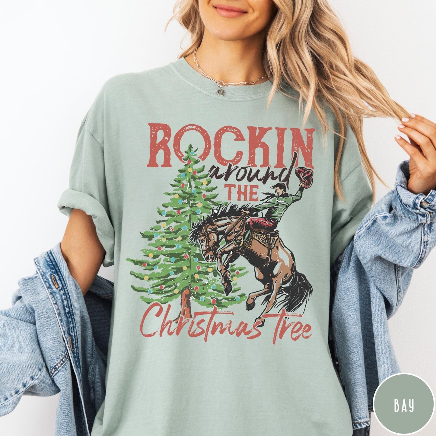 Comfort Colors tee in Bay featuring western graphic design of a cowboy on a bucking horse Christmas tree