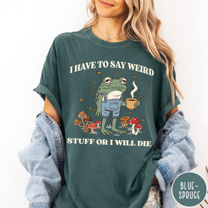 Comfort Colors tee in Blue Spruce featuring illustrative frog graphic with coffee cup and various forest mushrooms