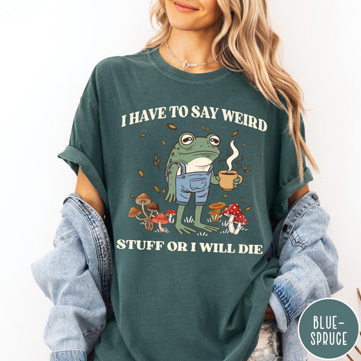 Comfort Colors tee in Blue Spruce featuring illustrative frog graphic with coffee cup and various forest mushrooms