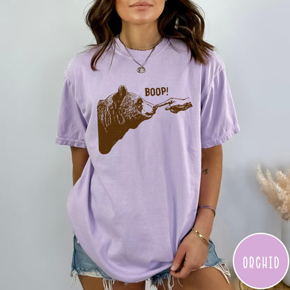 Comfort Colors tee in Orchid featuring a brown ink graphic of a human finger booping a bear nose