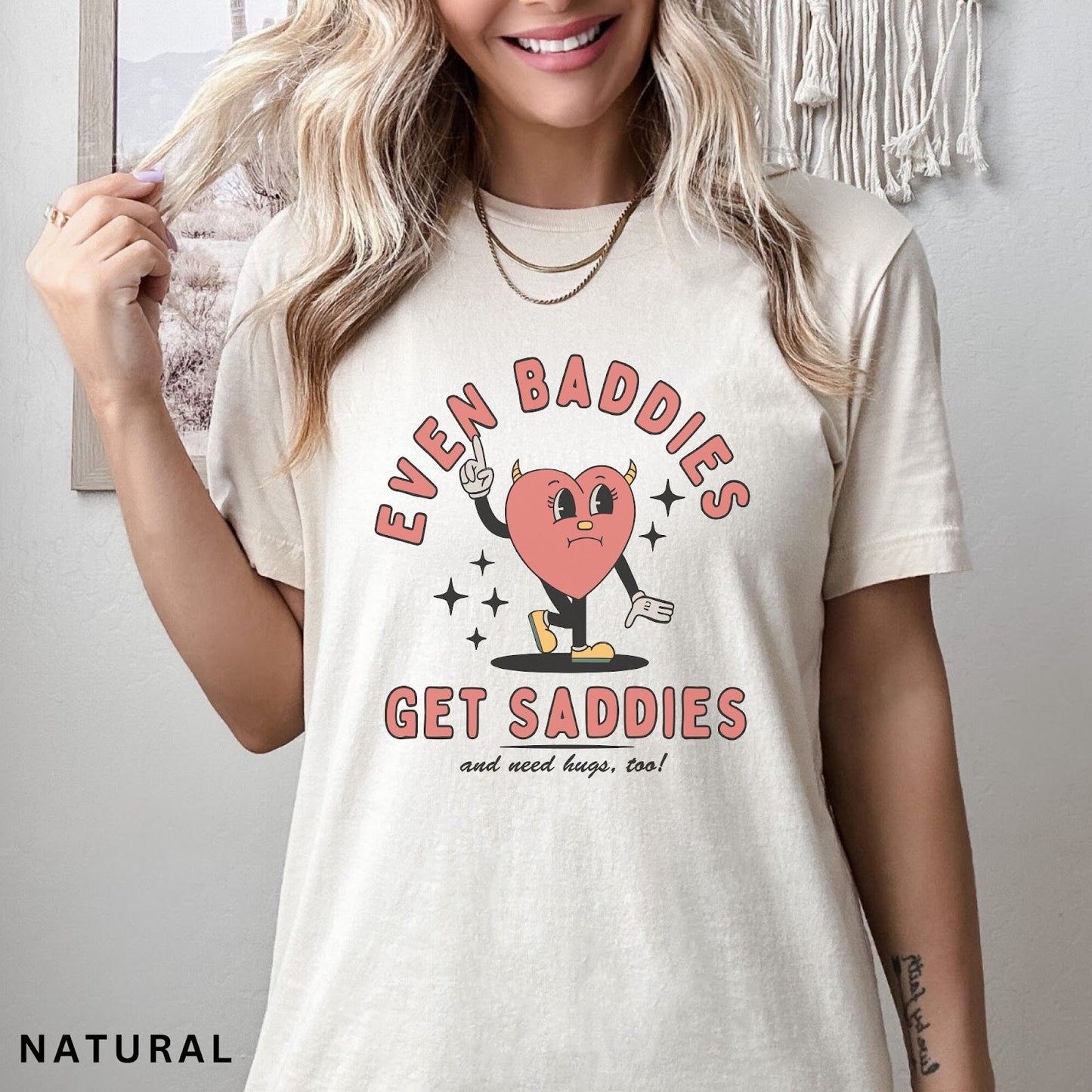 Comfort Colors tee in Natural featuring retro style sad heart character with horns and text graphic