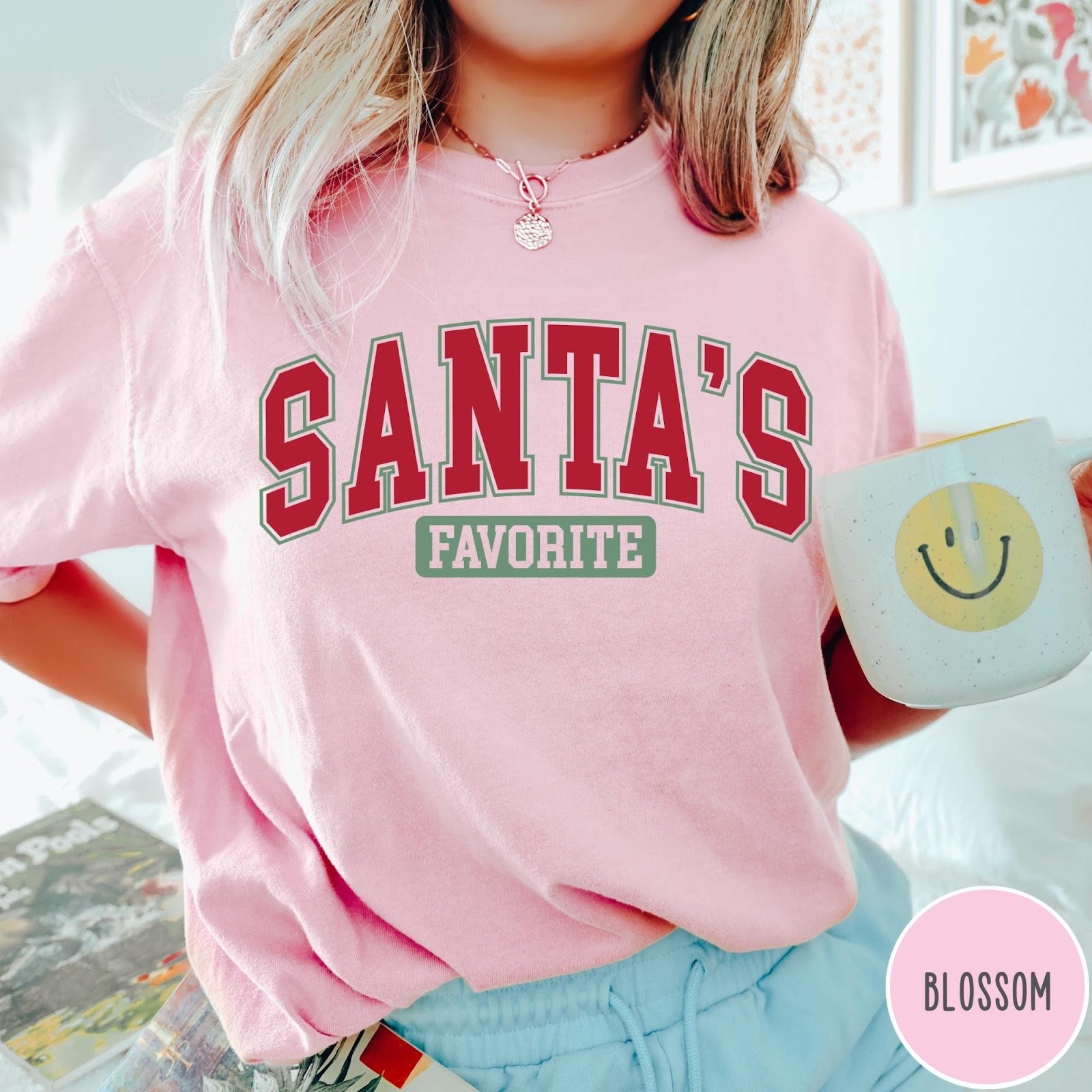 Comfort Colors tee in Blossom featuring collegiate style Santa's Favorite Christmas graphic with red and green text