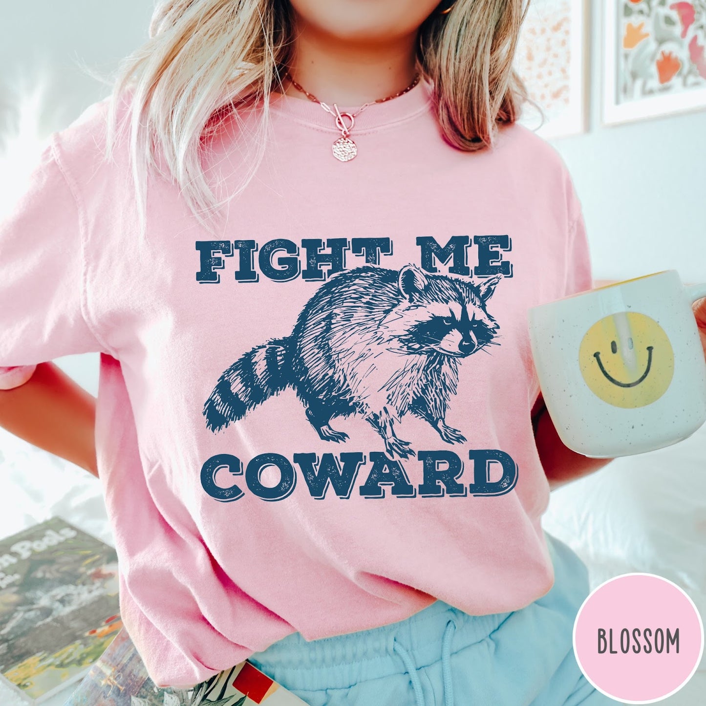 Comfort Colors tee in Blossom featuring screen printed raccoon graphic with Fight Me Coward text design